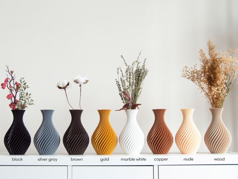 Pu&ograve; includere: Nove vasi in ceramica di diversi colori, tra cui nero, grigio argento, marrone, oro, bianco marmo, rame, nudo e legno. Ogni vaso ha un motivo a spirale unico.
