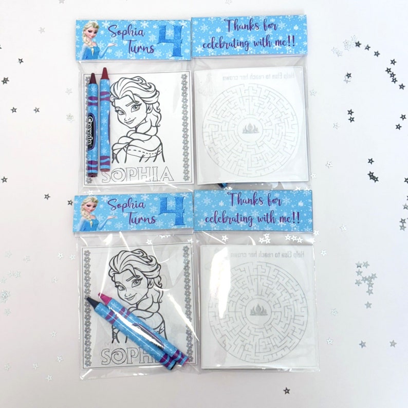 May include: Two clear plastic bags with a blue and white border. Each bag contains a colouring page featuring a character from the movie Frozen, two crayons, and a maze. The bags also have a blue and white label that says "Sophia Turns 4" and "Thanks for celebrating with me!!"