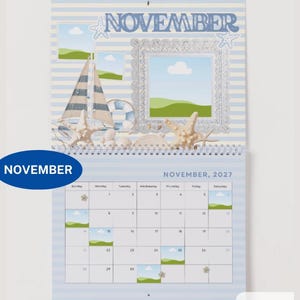May include: A wall calendar for November 2027 featuring a nautical theme with light blue and white stripes. The top section displays the word NOVEMBER, a sailboat, a life preserver, starfish, and a decorative silver frame with landscape art.