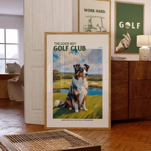 May include: A vintage-style poster featuring a blue merle Australian Shepherd dog sitting on a golf course. The poster has the text "The Good Boy Golf Club" and the tagline "Work hard play golf enjoy the sunshine."