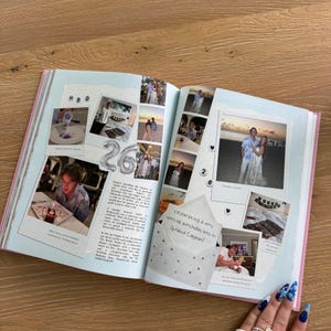 Pu&ograve; includere: Un album di ritagli aperto con diverse fotografie, testo scritto a mano ed elementi decorativi. Le pagine mostrano i ricordi di una festa per il 26&deg; compleanno, incluse immagini di una persona, un tramonto sulla spiaggia e una nota che dice celebrating a very special birthday boy in Grand Cayman.