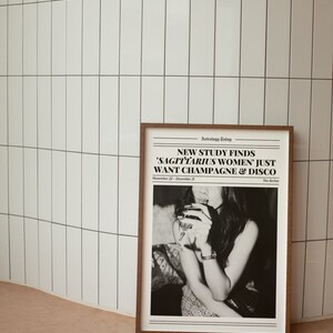 May include: A black and white newspaper print with the headline "NEW STUDY FINDS 'SAGITTARIUS WOMEN' JUST WANT CHAMPAGNE & DISCO" and the text "Astrology Today" and "The Archer". The image shows a woman holding a glass of wine.