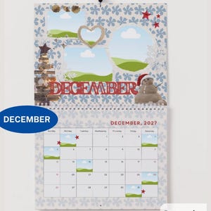 May include: A wall calendar for December 2027 featuring a light blue background with a white floral pattern. The top section displays a snowman, a wooden tree, and photo frames. The bottom section shows a grid calendar with the text DECEMBER 2027.