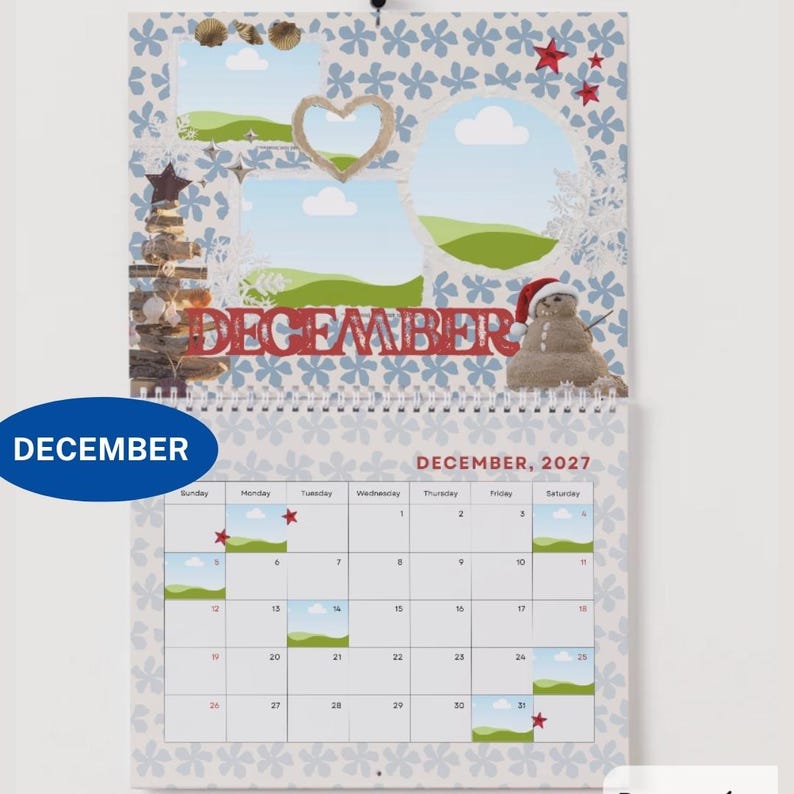 May include: A wall calendar for December 2027 featuring a light blue background with a white floral pattern. The top section displays a snowman, a wooden tree, and photo frames. The bottom section shows a grid calendar with the text DECEMBER 2027.