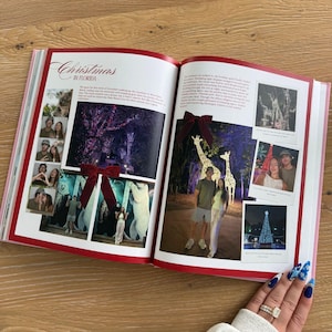 Pu&ograve; includere: Un libro fotografico aperto intitolato Christmas in Florida che presenta diverse pagine di fotografie stampate. Le pagine mostrano vari scatti di persone, sculture di animali illuminate e decorazioni luminose natalizie, con fiocchi rossi decorativi.