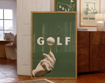 May include: A green poster with the word "GOLF" in white letters. A white golf ball is on a tee held by a gloved hand. The poster is framed in wood.