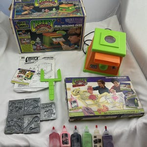 May include: A vintage Creepy Crawlers Workshop set, featuring a Real Molding Oven, molds, and bottles of colorful plastic goo. The box shows children using the oven to create creepy crawly creatures. Includes a Graveyard Ghoulies set.
