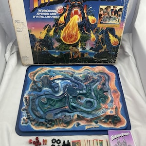 May include: Vintage Fireball Island board game. The box features a volcano spewing fire, with the game board below. Includes game pieces, cards, and instructions. For 2 to 4 players, ages 7 and up.