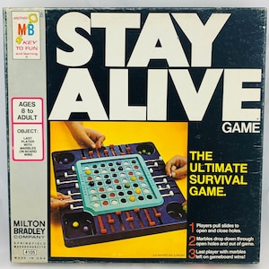 Pode incluir: Jogo de tabuleiro vintage "Stay Alive" da Milton Bradley. A caixa &eacute; azul escuro com o t&iacute;tulo do jogo em letras brancas grandes. O tabuleiro &eacute; vis&iacute;vel, com uma grelha, bolas de gude e mecanismos deslizantes. Para maiores de 8 anos.