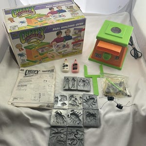 May include: A vintage Creepy Crawlers Workshop set, featuring a Real Molding Oven, molds, and accessories. The box displays the product name and images of children using the set. Includes bottles of glue and various bug-shaped molds.