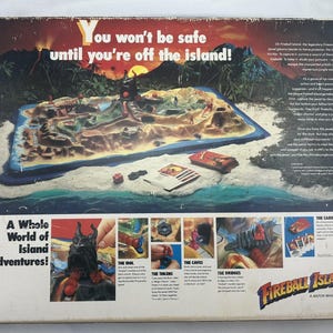 May include: Fireball Island board game box. The box features a colorful illustration of an island with a volcano, ocean, and jungle. Text on the box reads "You won't be safe until you're off the island!" and "A Whole World of Island Adventures!"