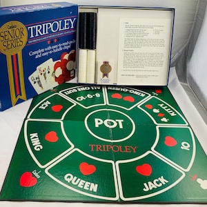 May include: A Tripoley Senior Series board game set including a blue box with game title and card graphics, a green folding game board with white text and red heart symbols, stacks of black and white plastic chips, and a printed instruction sheet.