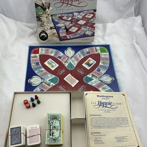 May include: The Yuppie Game board game by Waddingtons. The box and game board are visible, along with game pieces, dice, play money, and cards. The box reads "The Yuppie Game" and "It's not just a game. It's a way of life!"
