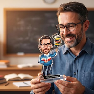 Puede incluir: Una figura transparente de acrílico de un profesor con un hombre de dibujos animados sosteniendo libros. La figura tiene una base negra con el texto "First & Last Name". El hombre de la imagen está sonriendo y usando gafas.