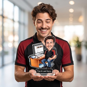 May include: A personalized acrylic desk ornament featuring a cartoon caricature of a person at a computer desk. The ornament includes the text "First & Last Name" on the base. The person in the image is smiling and holding the ornament.