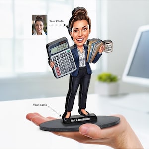 Può includere: Una statuetta caricaturale personalizzata di un contabile con blazer blu navy e pantaloni neri. La figura tiene in mano una calcolatrice, una pila di cartelle etichettate Taxes, Audit, Ledgers e una tazza con scritto Bean Counter Queen.