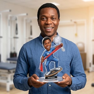 May include: A person smiling and holding a clear acrylic award. The award depicts a cartoon figure in blue scrubs holding a red resistance band and a goniometer. The base of the award has the text "First & Last Name".