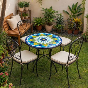 Peut inclure: Une table de bistrot ronde avec un plateau en mosaïque colorée présentant un motif floral géométrique bleu, jaune, vert et blanc, accompagnée de trois chaises en métal noir avec des coussins beiges et un dossier incurvé.