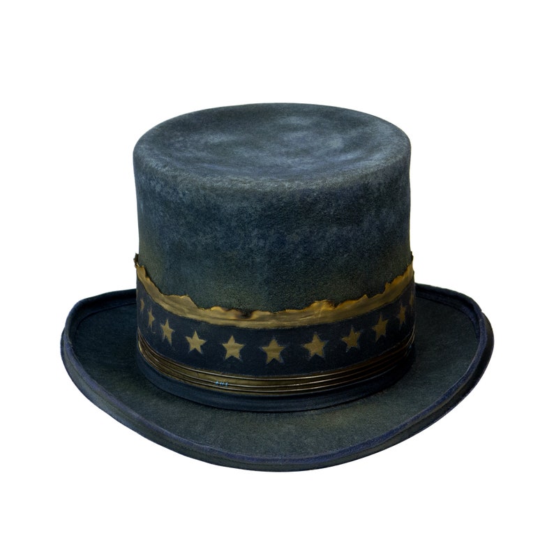 May include: A dark blue top hat with a gold and black band and stars around the band. The hat has a worn, vintage look.