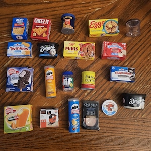 May include: A collection of miniature food and household product replicas including boxes of Pop-Tarts, Cheez-It, Eggo, Hostess Twinkies, Hostess Cupcakes, and Good Humor ice cream, along with containers of Planters, Breyers, Pringles, Jif, Cafe Bustelo, and Columbus.