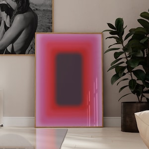 May include: A living room interior with a white sofa, a glass coffee table, a potted plant, and two framed pictures on the wall. One picture is a black and white photograph of a woman, and the other is a pink and purple abstract painting.