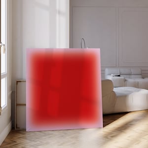Puede incluir: Una gran pintura abstracta con un degradado rojo, enmarcada en un marco blanco. La pintura está colgada en una pared blanca en una sala de estar moderna.