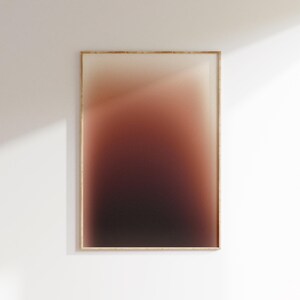 May include: A framed art print featuring a colour gradient. The artwork fades from a light beige at the top to a dark burgundy at the bottom. The frame is light wood, and the print is displayed on a white wall.