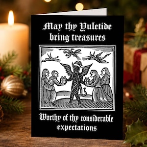 May include: A black greeting card with white text that reads May thy Yuletide bring treasures and Worthy of thy considerable expectations. The centre features a black and white woodcut illustration of a horned figure wearing a Santa hat.