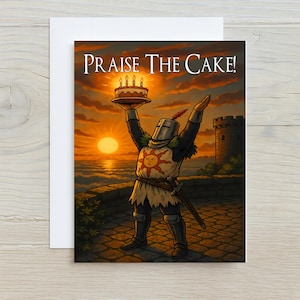 May include: Greeting card with a knight holding a cake with lit candles, arms raised in celebration. The text "Praise The Cake!" is above the knight. The background shows a sunset over the ocean, with a castle tower on the right.
