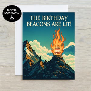 May include: A birthday card with the words "THE BIRTHDAY BEACONS ARE LIT!". The image shows a cake on a mountain with flames, set against a blue sky and mountain range. A digital download icon is in the upper left corner.