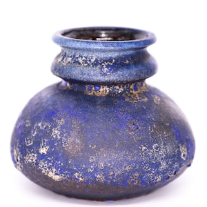 May include: A blue ceramic vase with a textured surface. The vase has a rounded body and a wide mouth.