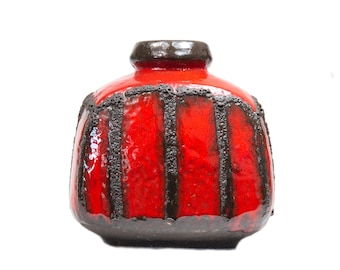 Pode incluir: Vaso de cerâmica vermelho com design geométrico preto. O vaso tem uma forma arredondada e atarracada e um acabamento brilhante.