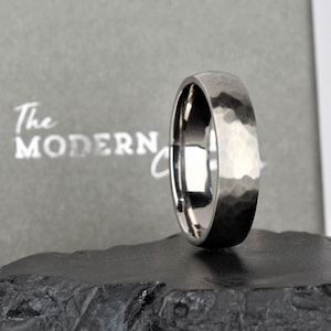 men wedding ring band in the alternative metal of titanium. hammered finish and polished inside the ring is 6mm wide and comes in a recycled material ring box