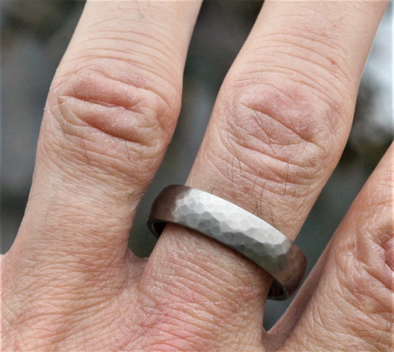 men's wedding ring band in the alternative metal of titanium. This ring has a hammered finish and polished inside the ring is 6 millimetres wide and comes in a recycled material ring box