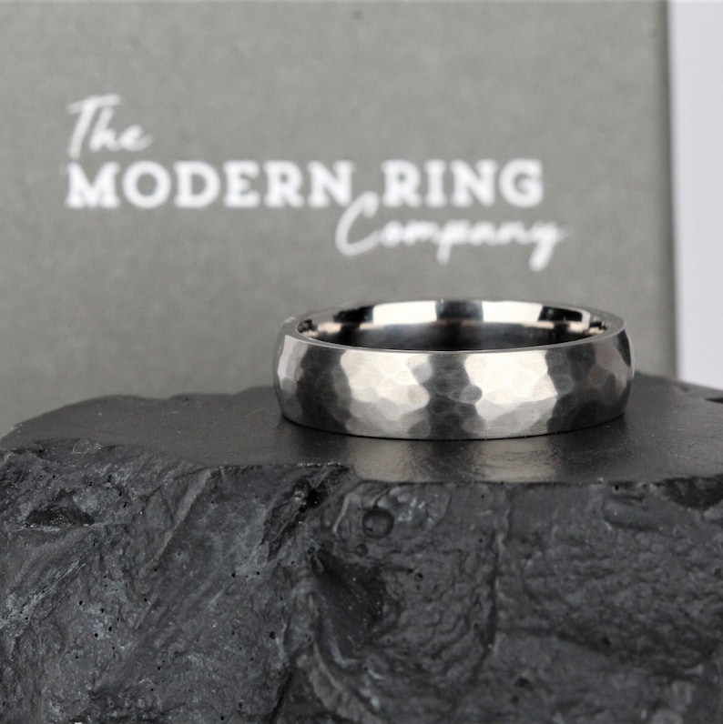 men's wedding ring band in the alternative metal of titanium. This ring has a hammered finish and polished inside the ring is 6 millimetres wide and comes in a recycled material ring box