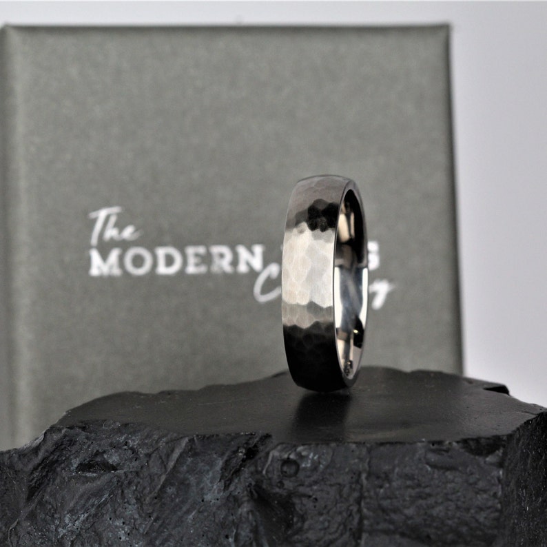 mens or womans wedding ring band in the alternative metal of titanium. This ring has a hammered finish and polished inside the ring is 6 millimetres wide and comes in a recycled material ring box