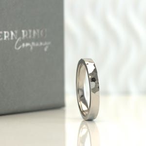 May include: A silver hammered wedding band with a smooth, polished interior.
