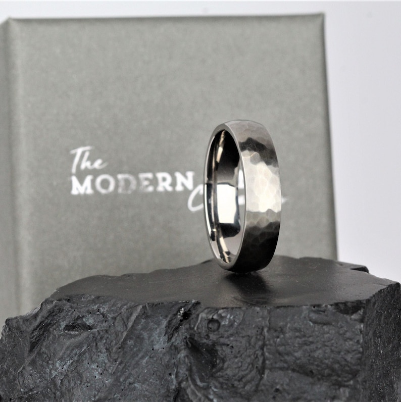 men wedding ring band in the alternative metal of titanium. hammered finish and polished inside the ring is 6mm wide and comes in a recycled material ring box