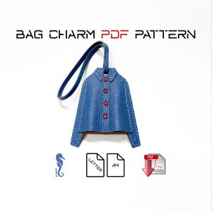 May include: A blue leather jacket-shaped bag charm with red buttons and a blue strap. The charm is stitched with white thread. The image includes the text "BAG CHARM PDF PATTERN".