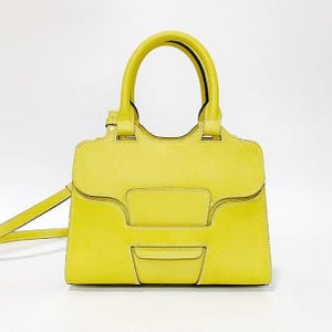 May include: A bright yellow structured handbag with a smooth leather-like finish, featuring two top handles, a flap closure with a central geometric panel, visible white stitching, and a thin detachable shoulder strap extending to the left side.