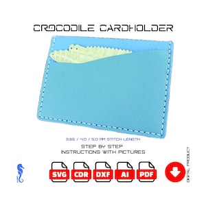May include: A light blue cardholder featuring a crocodile design. The cardholder has a light blue exterior and a lighter blue interior. The text "CROCODILE CARDHOLDER" is at the top. The image also includes file type icons.