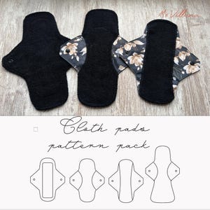 Pode incluir: Três pensos menstruais de tecido reutilizáveis. Dois são pretos lisos e um tem um padrão floral com flores bege e castanhas sobre um fundo escuro. Os pensos são exibidos sobre um fundo claro com o texto "Cloth pads pattern pack".