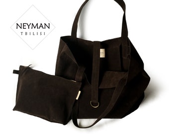 May include: A brown suede tote bag with a smaller matching pouch. The bag has a long strap and a top handle. The bag has a label that says "NEYMAN TBILISI".