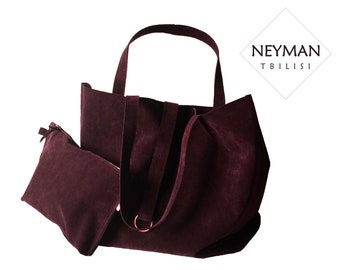 May include: A burgundy suede tote bag with a matching burgundy suede pouch. The bag has a single top handle and a detachable shoulder strap. The bag has the text "NEYMAN TBILISI" on a white diamond-shaped tag.