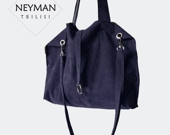 May include: A dark blue canvas tote bag with a long shoulder strap and two shorter straps. The bag has silver metal hardware and the text "NEYMAN TBILISI" is printed on the front.