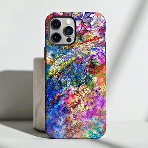 Puede incluir: Una funda de teléfono abstracta colorida con un diseño azul, rosa, amarillo y dorado. La funda tiene un recorte para la cámara de un iPhone.