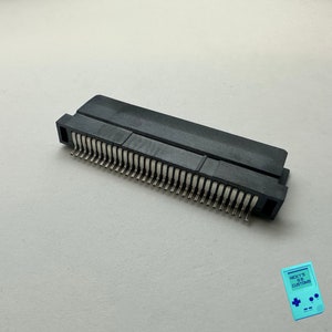 May include: A black plastic connector with a row of silver pins. The connector is designed for electronic devices.