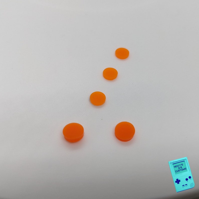 Peut inclure: Cinq boutons ronds orange sur un fond blanc. Les boutons sont dispos&eacute;s en un motif, avec deux boutons en bas, deux boutons au milieu et un bouton en haut.
