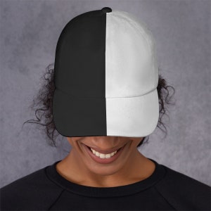 May include: A black and white baseball cap with a straight brim. The cap is split down the middle, with one half black and the other half white.
