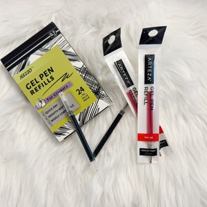 May include: A pack of 24 black gel pen refills for clicker pens, a pack of red gel pen refills, and two black gel pen refills. The packaging for the refills has the text "JEEZZO GEL PEN REFILLS For Clickers 24 Value Pack" and "ARTEZA GEL PEN REFILL".